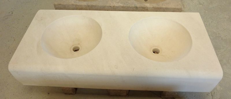 Bel évier en pierre naturelle de taille pour salle de bain par les ateliers Alain Bidal.
