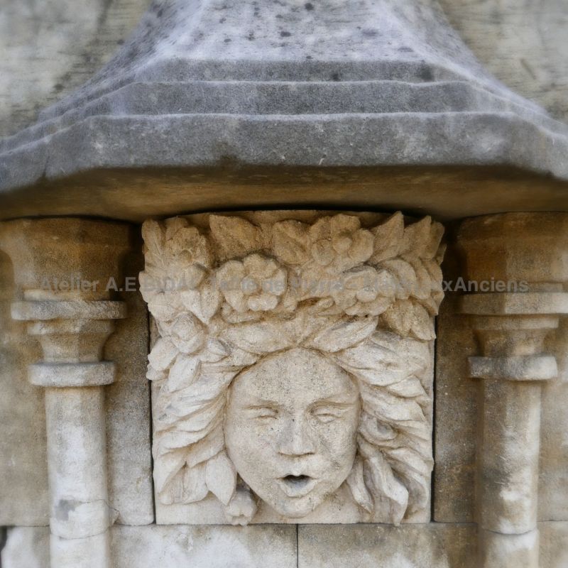 Tête de méduse sculptée en pierre sur fontaine en pierre naturelle de l'Atelier Bidal