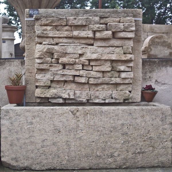 Garden wall fountain - an element of outdoor decoration in stone from Alain Bidal in Provence.