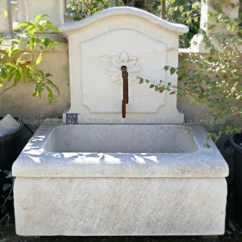 Fontaine décorative pour jardin avec bac massif et fronton sculpté par l'artisan tailleur de pierre Alain BIDAL.