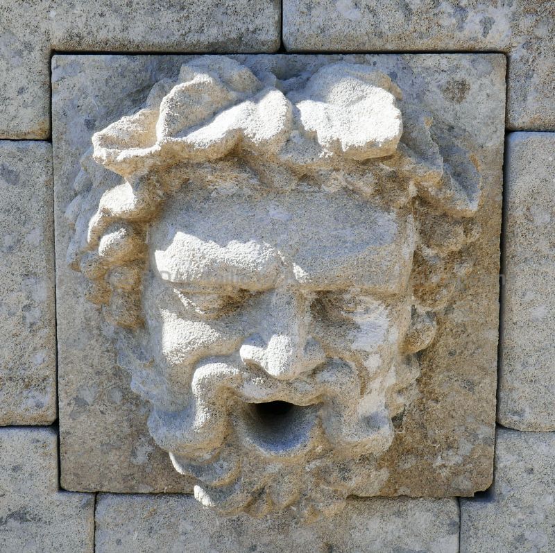 Hand-sculpted water outlet in stone representing the head of Bacchus on our wall fountain - Atelier Alain BIDAL (Provence)