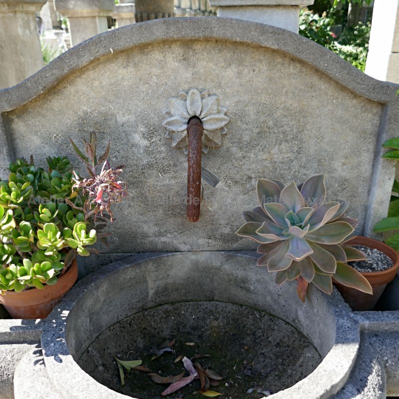 Sortie d'eau en fer forgé sur le fronton en pierre de notre fontaine de jardin décorative | Atelier Alain BIDAL