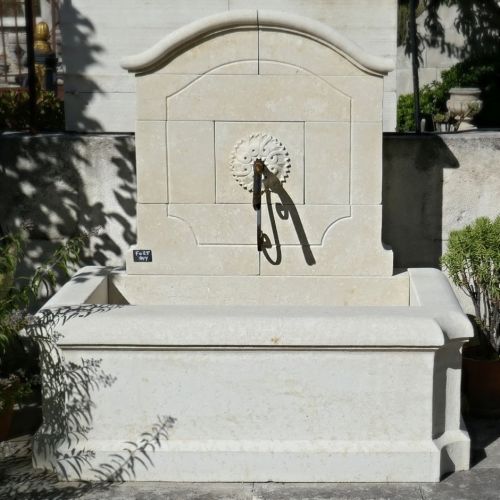 Une fontaine de jardin avec fronton et grand bassin de l'atelier Alain Bidal.
