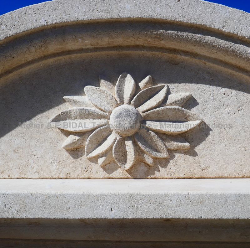 Fleur sculptée à la main sur la corniche moulurée de notre large fontaine en pierre à tête de lion
